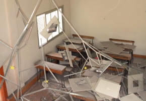Ein beschädigter Klassenraum mit Schutt und herabhängenden Deckenelementen