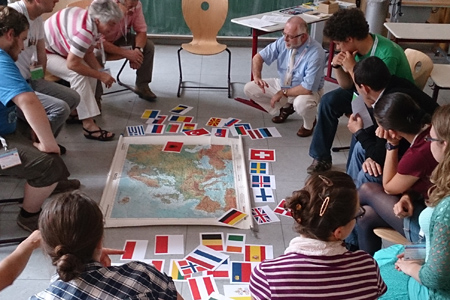 Menschen beugen sich über eine auf dem Boden liegende Europakarte