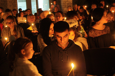 Menschen im Gottesdienst mit Kerzen in der Hand
